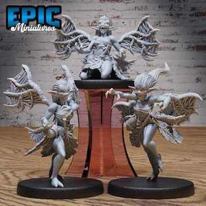 Puede incluir: Tres figuras en miniatura grises de criaturas aladas con dientes afilados y orejas puntiagudas. Una figura está arrodillada sobre una plataforma, mientras que otras dos están de pie sobre bases negras. Las figuras tienen alas detalladas y son de Epic Miniatures.