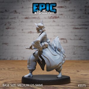 May include: A gray painted miniature figurine of a person with a fox tail and a sword. The person is wearing a long robe and has a mask in their hand. The base is black and reads "EPIC Miniatures" and "#3575".