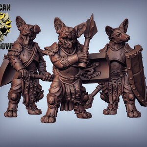 May include: Three miniature figures of canine warriors wearing armour and holding weapons. The figures are painted in a brown colour and have a detailed sculpt.