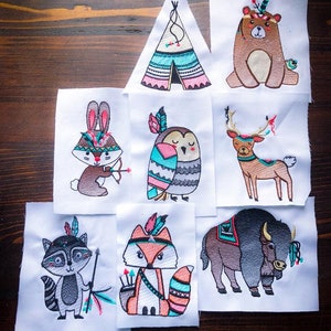 May include: Seven embroidered patches featuring various animals wearing Native American headdresses. The animals include a bear, a deer, a fox, a raccoon, a rabbit, an owl, and a buffalo. The patches are all white with colorful embroidery.