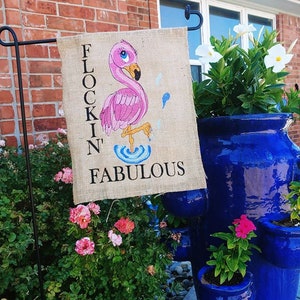 May include: A burlap garden flag with a pink flamingo illustration and the text "Flockin' Fabulous".