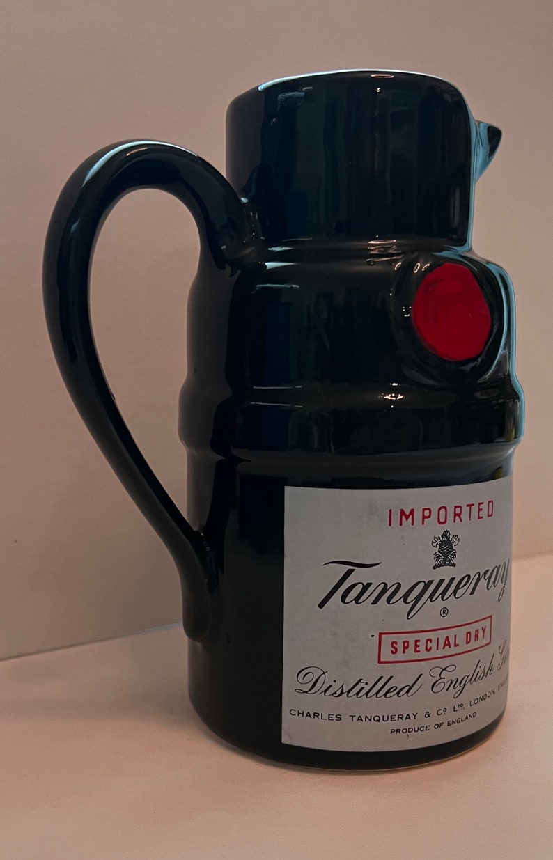 Op de afbeelding: Zwarte keramische kan met een rode waszegel en een etiket met de tekst "IMPORTED Tanqueray SPECIAL DRY Distilled English Gin CHARLES TANQUERAY & CO LTD LONDON PRODUCE OF ENGLAND"