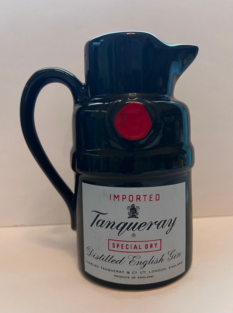 Op de afbeelding: Zwarte keramische kan in de vorm van een Tanqueray-ginfles. De fles heeft een rode zegel en de tekst "IMPORTED Tanqueray SPECIAL DRY Distilled English Gin CHARLES TANQUERAY & CO LTD LONDON, ENGLAND PRODUCE OF ENGLAND"