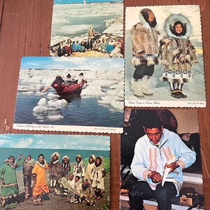 May include: Five vintage postcards depicting scenes of Inuit life in Alaska. The postcards feature images of people in traditional clothing, fishing on the ice, and carving ivory. The text on the postcards reads "Eskimo Fishing in the Arctic Ice", "Eskimo Couple in Parkas, Alaska", "Eskimo Dancers in Alaska", and "Eskimo Ivory Carver at Work".