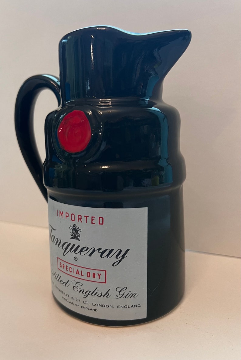 Op de afbeelding: Zwarte keramische kan met een rode zegel en een wit etiket met de tekst "IMPORTED Tanqueray SPECIAL DRY Distilled English Gin TANQUERAY & CO LTD LONDON, ENGLAND PRODUCE OF ENGLAND"