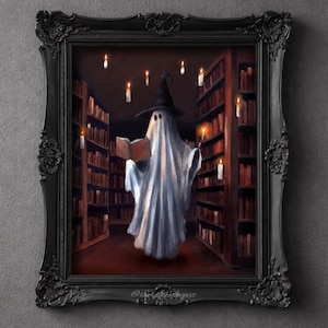 Puede incluir: Una obra de arte enmarcada en un marco negro adornado representa un fantasma con un sombrero de bruja leyendo un libro en una biblioteca, rodeado de velas flotantes. El fantasma sostiene una varita con una vela encendida. Tema mágico y espeluznante.