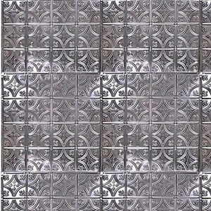 May include: A close-up of a silver metal ceiling tile with a repeating pattern of embossed leaves and geometric shapes.