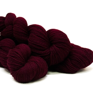 May include: A skein of deep burgundy yarn, wound into a ball shape.
