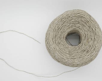 May include: A large, tightly wound ball of natural-colored twine with a loose strand extending to the left. The twine appears to be made of a fibrous material, possibly linen or hemp, and is set against a plain white background.