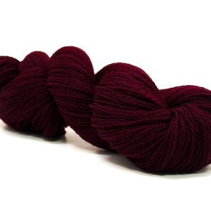 May include: A skein of deep burgundy yarn, wound into a heart shape, ready for knitting or crocheting.