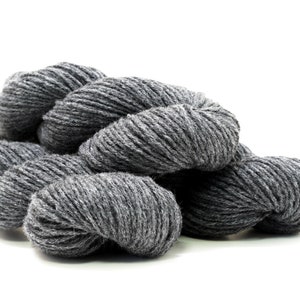 Peut inclure: Gros plan sur un écheveau de fil gris. Le fil est doux et moelleux, idéal pour le tricot ou le crochet.