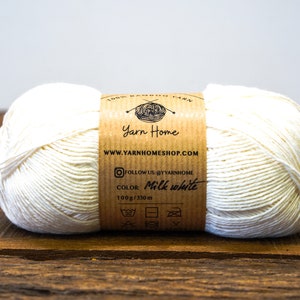 May include: A skein of 100% bamboo yarn in the color milk white. The yarn is 100 grams and 330 meters long. The label includes the brand name "Yarn Home" and the website address "www.yarnhomeshop.com".