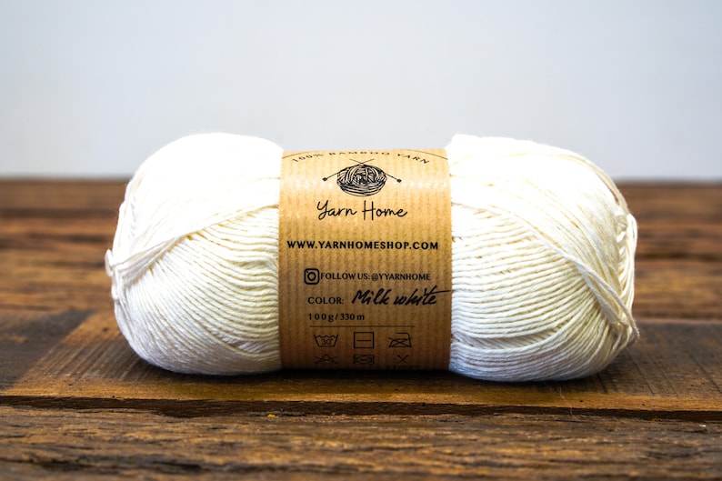 May include: A skein of 100% bamboo yarn in the color milk white. The yarn is 100 grams and 330 meters long. The label includes the brand name "Yarn Home" and the website address "www.yarnhomeshop.com".