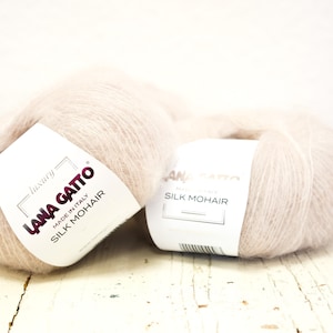 Può includere: Due gomitoli di filato di mohair e seta Lana Gatto color rosa pallido. Il filato è prodotto in Italia ed è etichettato come "luxury".