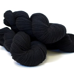 May include: A skein of black yarn, a soft and fluffy material for knitting or crocheting.