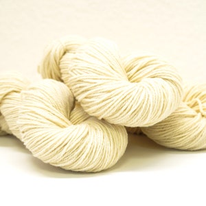 May include: Three skeins of natural white yarn, a soft and fluffy material for knitting or crocheting.