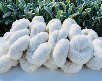 May include: A pile of white yarn skeins, ideal for knitting or crocheting.