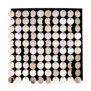 May include: A black square-shaped backdrop with a grid of round, silver sequins. The sequins are evenly spaced and create a shimmering effect.