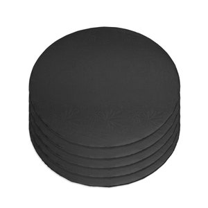 May include: A stack of six black round cake boards. The boards are made of cardboard and have a decorative pattern.