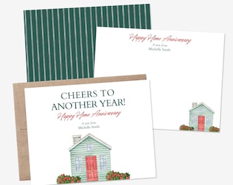 May include: Two white stationery cards and a brown envelope. One card features a green house with a red door, red flowers, and the text "CHEERS TO ANOTHER YEAR! Happy Home Anniversary A note from Michelle Smith." The other card has similar text.