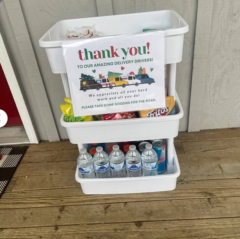 Puede incluir: Un carro de tres niveles blanco con ruedas con un cartel que dice "&iexcl;gracias! A nuestros incre&iacute;bles repartidores!" El carro est&aacute; lleno de bocadillos y bebidas, incluyendo botellas de agua, patatas fritas y dulces. El cartel tambi&eacute;n dice "&iexcl;Apreciamos todo tu trabajo duro y todo lo que haces! Por favor, toma algunas golosinas para el camino."