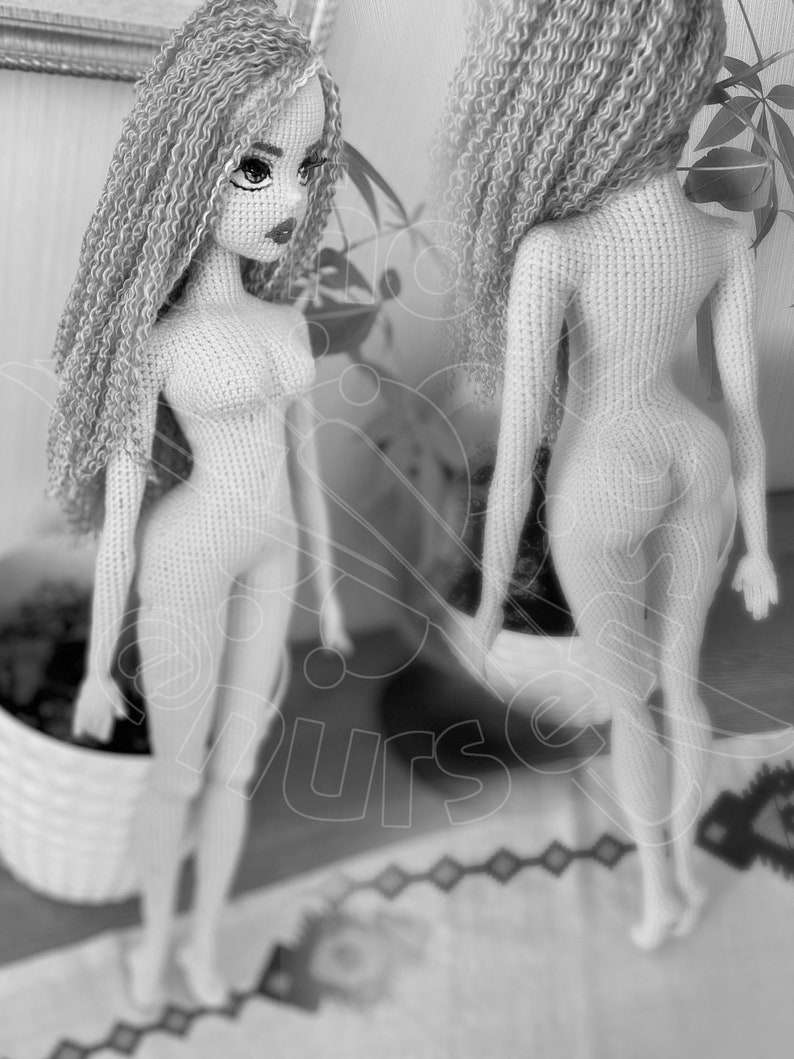 May include: A crocheted doll with long, curly hair. The doll is nude and has a detailed face with painted eyes and lips.