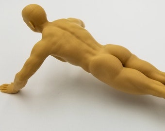 May include: A nude figurine of a person doing a push-up exercise. The figurine is made of a light brown material and is posed in a realistic position.