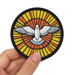 Op de afbeelding: Een witte duif met een rood hart in zijn borst, vliegend in een cirkel van gele en oranje stralen, omringd door een zwarte rand.