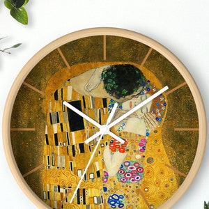 Puede incluir: Un reloj redondo de madera con una esfera blanca y agujas doradas. La esfera del reloj presenta una pintura de dos personas abrazándose, con un fondo dorado y detalles coloridos.