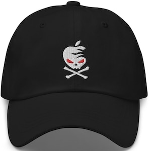 Può includere: Cappellino da baseball nero con un designo di teschio e ossa incrociate ricamate in bianco. Il teschio ha gli occhi rossi ed è all'interno di una forma di mela.