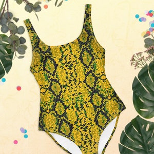 Op de afbeelding: Een geel en groen badpak met een slangenhuidpatroon.