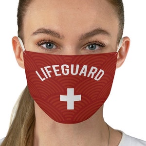 May include: A red face mask with a white lifeguard cross and the word "LIFEGUARD" printed on it.