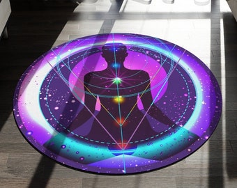 May include: A round, purple and blue yoga mat with a silhouette of a person meditating in the center. The person is surrounded by a geometric pattern and glowing lights.