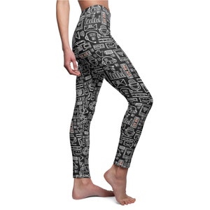 Puede incluir: Leggings negros con un patrón blanco y melocotón de varios iconos de medios, incluidos micrófonos, auriculares y las palabras "On Air".