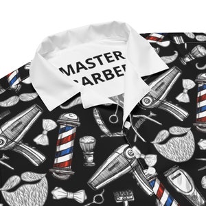 May include: Black and white patterned shirt with a white collar. The pattern includes barber poles, hair clippers, razors, mustaches, and hair dryers. The collar has the text "MASTER BARBER" printed on it.