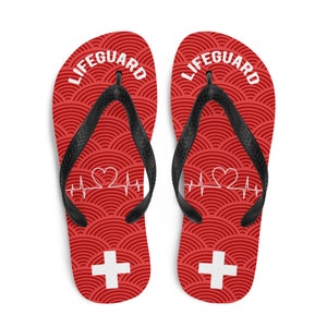 May include: Red flip flops with a white lifeguard cross and a white heartbeat with a heart graphic. The text "LIFEGUARD" is printed in white on the top of each flip flop.