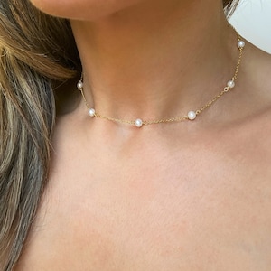 Puede incluir: Un delicado collar de cadena dorada con pequeñas perlas blancas. El collar es un diseño simple y elegante, perfecto para el uso diario.