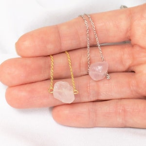 Puede incluir: Dos delicados collares con colgantes de cuarzo rosa. Un collar tiene una cadena de oro y el otro una cadena de plata.