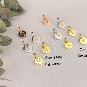 May include: Assortment of 8mm coin charms with different letters engraved in silver, gold, and rose gold. The charms have either a small or large letter engraved on them.  Coin 8MM Small Letter and Coin 8MM Big Letter are written below the charms.
