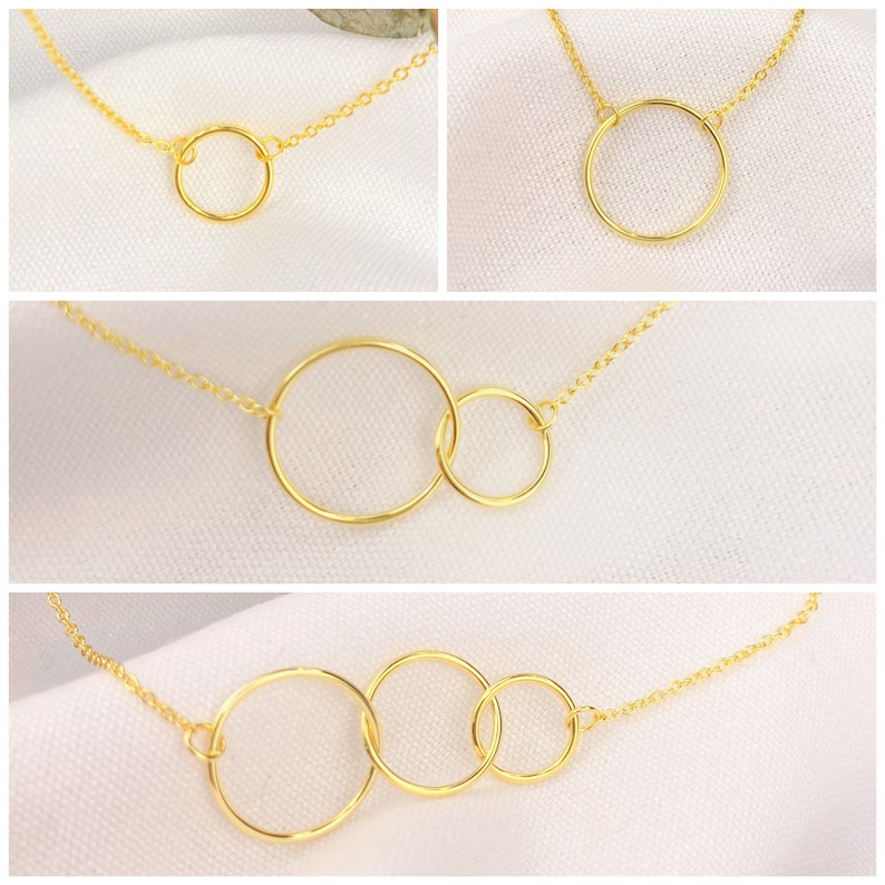 May include: Gold necklace with a single, double, and triple circle pendant. The circles are interlocked and the chain is delicate.