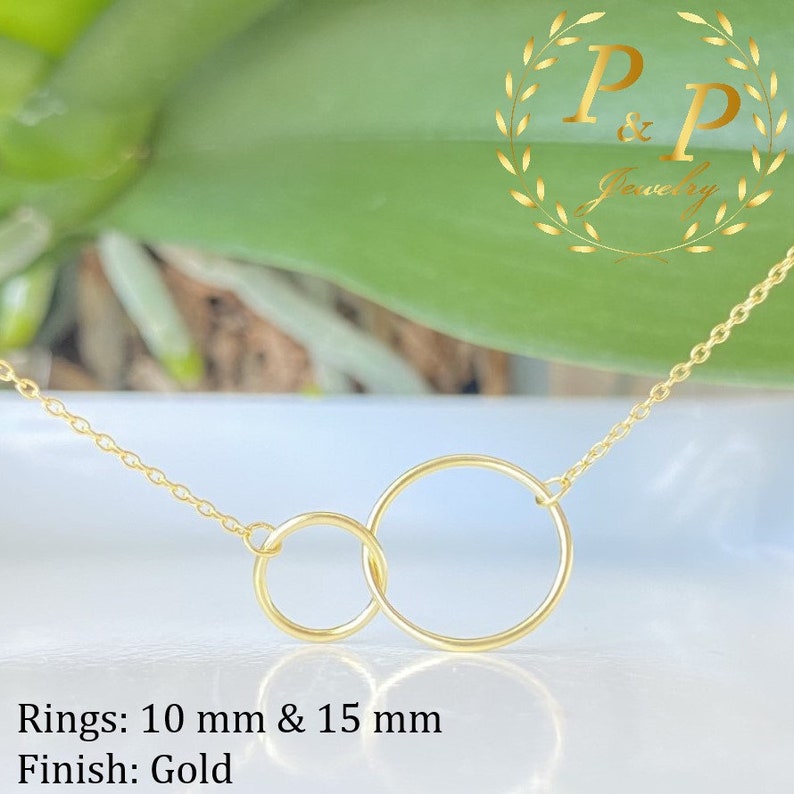 May include: Gold necklace with two interlocking circles, one 10 mm and the other 15 mm in diameter.  Rings: 10 mm & 15 mm Finish: Gold