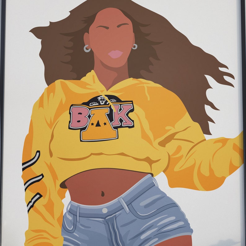 May include: A woman with long brown hair is wearing a yellow cropped hoodie with the letters "BAK" in pink and black on the front. She is also wearing blue denim shorts.