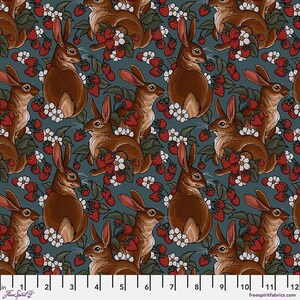 May include: A teal blue fabric with a repeating pattern of brown rabbits and red strawberries. The rabbits are depicted in a stylized, almost cartoon-like manner, with large ears and fluffy tails. The strawberries are scattered throughout the fabric, some with leaves and some without.