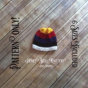 Może przedstawiać: Czapka na drutach w paski w kolorze żółtym, czerwonym, niebieskim, czarnym i białym. Czapka leży na drewnianym tle. Tekst "PATTERN ONLY" znajduje się po lewej stronie obrazu, a "6 SIZES INCLUDED" po prawej stronie obrazu.