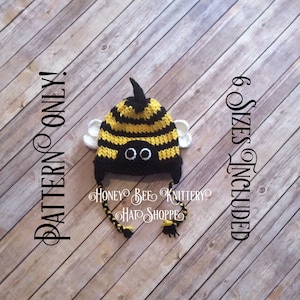 Puede incluir: Un gorro de abeja de crochet con rayas negras y amarillas, alas blancas y ojos negros. El gorro tiene una cola larga y está disponible en seis tallas. El texto "PATTERN ONLY" está escrito verticalmente en el lado izquierdo de la imagen y "6 SIZES INCLUDED" está escrito verticalmente en el lado derecho de la imagen.