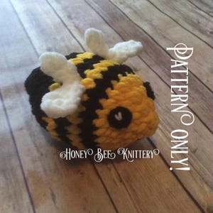 May include: A handmade crochet bee with yellow and black stripes, white wings, and a black eye. The text "PATTERN ONLY!" and "HONEY BEE KNITTERY" are visible on the image.
