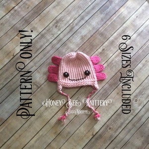 Puede incluir: Sombrero de axolotl de crochet rosa con ojos negros y una boca sonriente. El sombrero tiene una cola larga y está disponible en seis tamaños. El texto "PATTERN ONLY" y "6 SIZES INCLUDED" está en los lados izquierdo y derecho de la imagen.