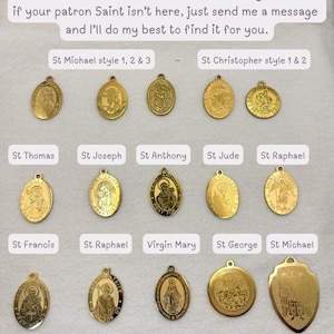 May include: A collection of gold-colored Saint charms in various shapes and designs. The charms feature images of saints such as St. Michael, St. Christopher, and St. Thomas. Text on the image reads, "Below are Saint charms I have available right now."
