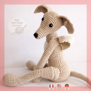 May include: A beige crochet dog toy with long ears, black eyes, and a black nose. The toy features small white wings on its back and a white patch on its chest. A circular graphic in the upper left corner contains the text PDF PATTERN CROCHET.