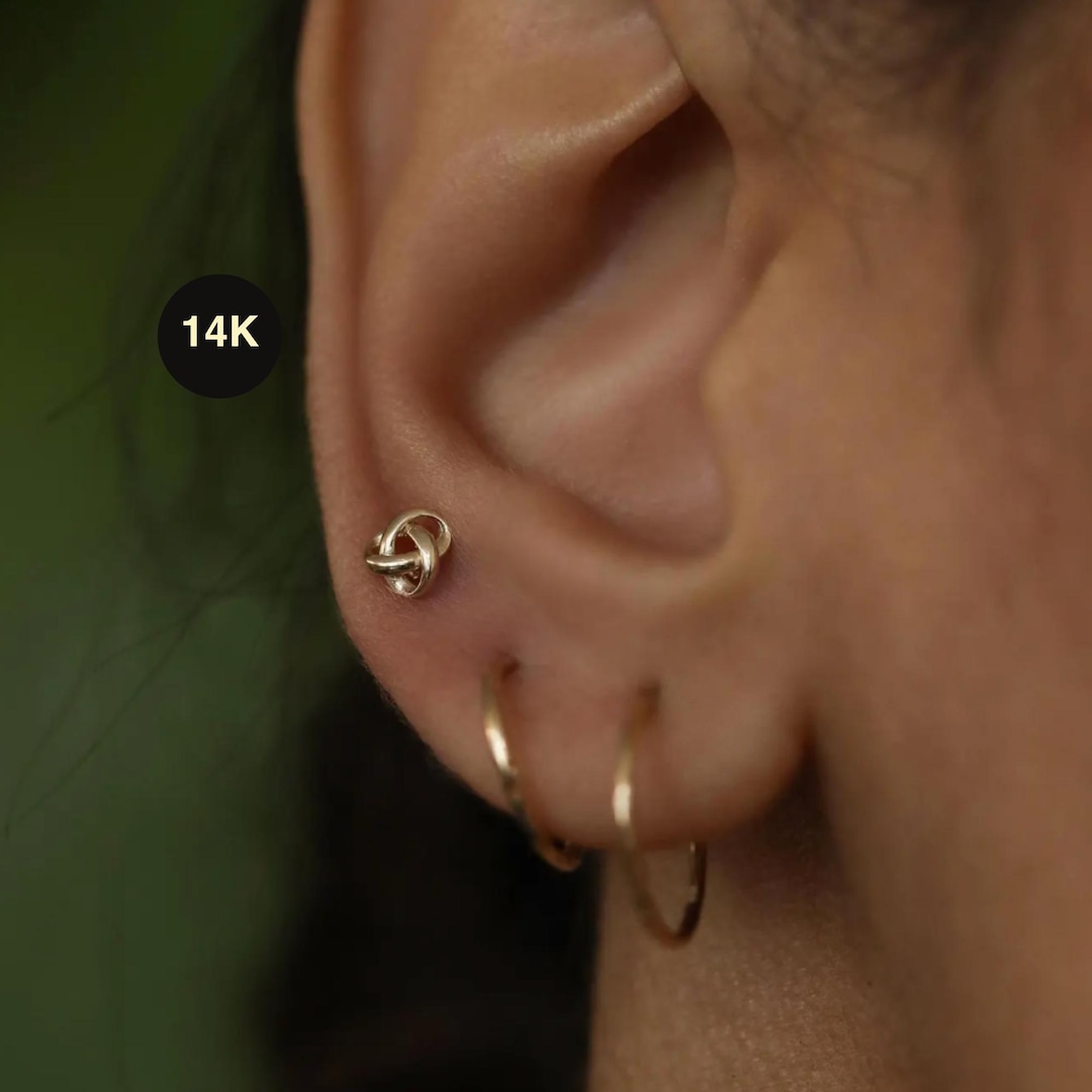 Aretes tipo botón con símbolo infinito de nudo de amor en oro